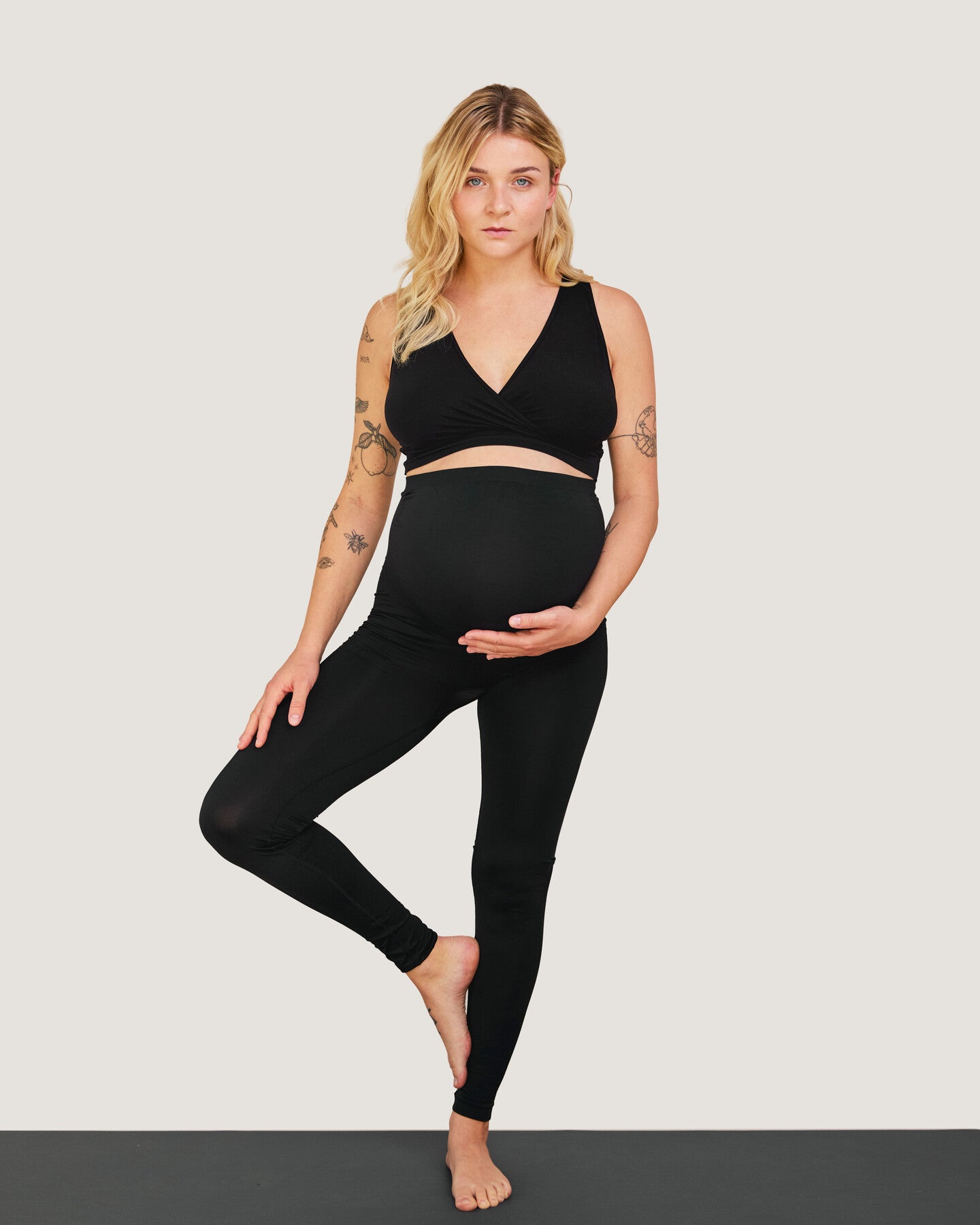Schwangere Frau macht Yoga in nahtlosen Carriwell-Leggings